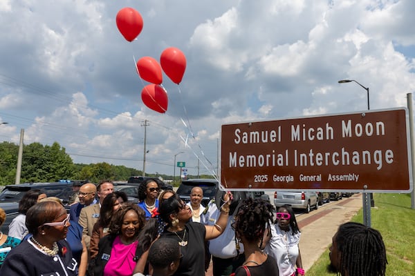 Family and supporters gather to celebrate the unveiling of a state road sign dedicated to Samuel Micah Moon at I-20 and Ga. 92 in Douglasville on Monday. (Arvin Temkar / AJC)