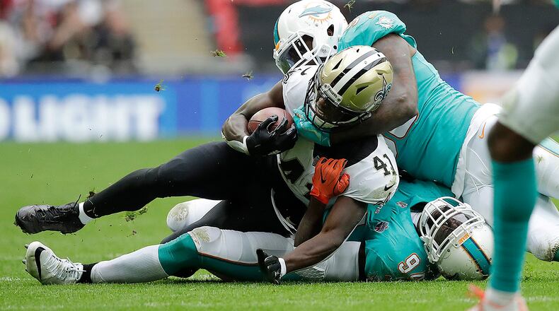 New Orleans Saints running back Alvin Kamara (41) is tackled during the first half of an NFL football game against the Miami Dolphins at Wembley Stadium in London, Sunday Oct. 1, 2017. (AP Photo/Matt Dunham)
