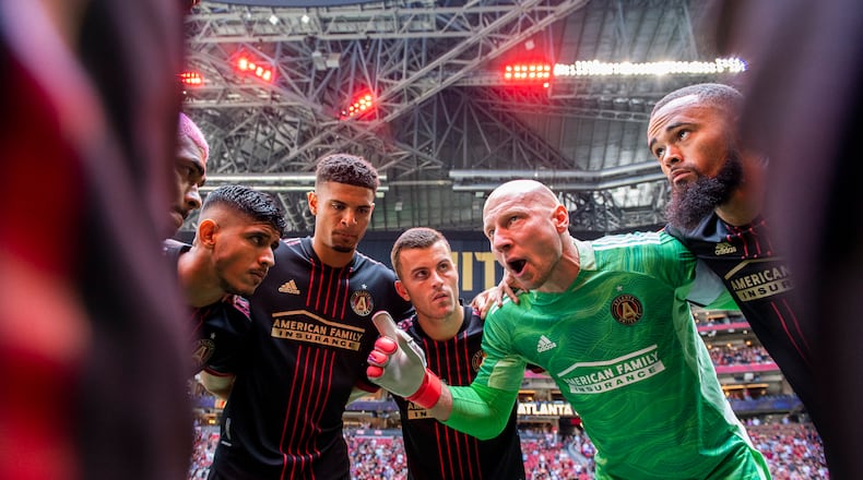 Atlanta United starting 11 - led by goalkeeper Brad Guzan (in green) - huddle before match against Nashville Saturday, Aug. 28, 2021, at Mercedes-Benz Stadium in Atlanta. (Jacob Gonzalez/Atlanta United)