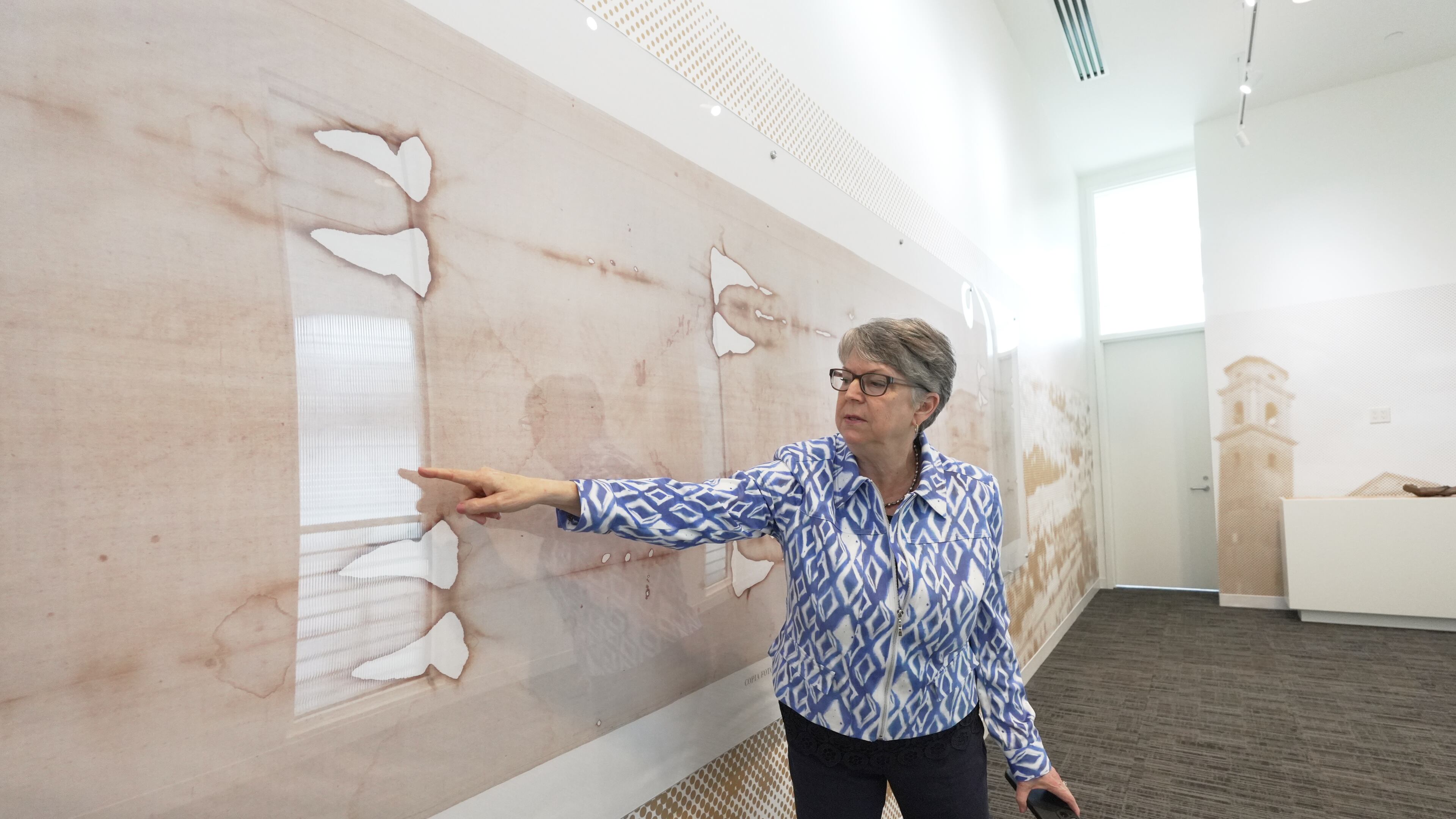 Nora Creech, director of Othonia North America, points to a replica of the Shroud of Turin at a new interactive museum dedicated to the shroud, Monday, Nov. 17, 2025, at the Christ Cathedral campus in Garden Grove, Calif. (AP Photo/Krysta Fauria)