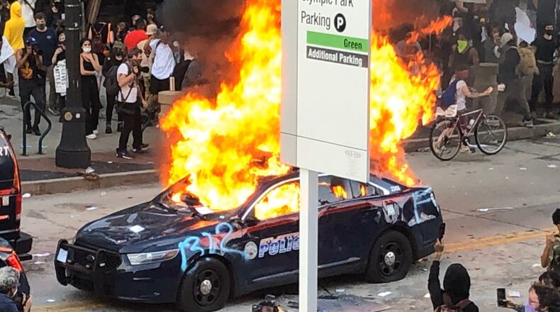 An Atlanta Police Department car is on fire as protests turned chaotic outside the CNN Center Friday evening.