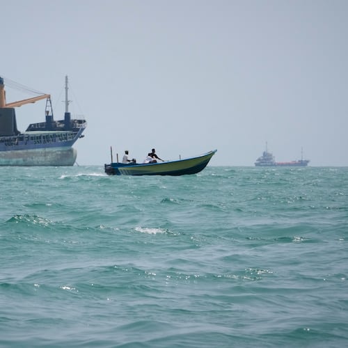 A motorboat passes a general cargo ship anchored in the Strait of Hormuz off Bandar Abbas, Iran, Sunday, Sept. 6, 2026. (AP Photo/Vahid Salemi)