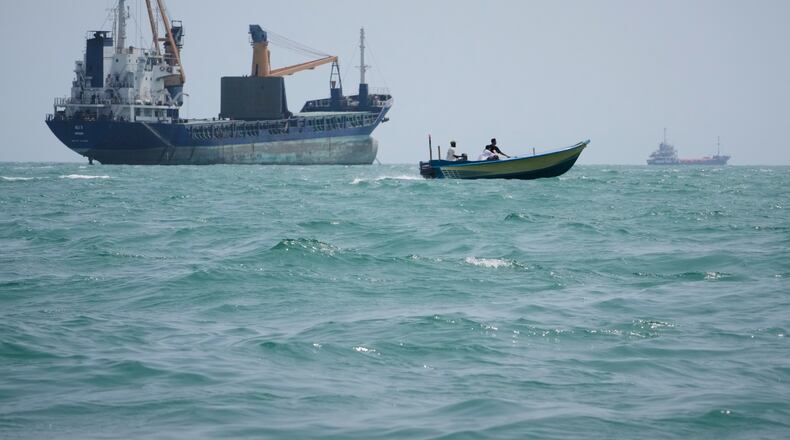 A motorboat passes a general cargo ship anchored in the Strait of Hormuz off Bandar Abbas, Iran, Sunday, Sept. 6, 2026. (AP Photo/Vahid Salemi)