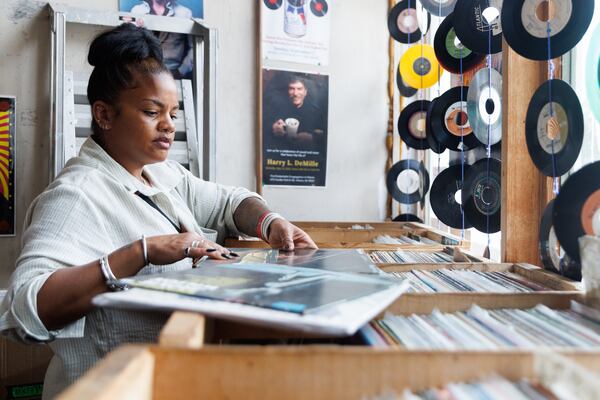 Sharah Brame sifts through boxes of records at Wax ’n’ Facts. (Estela Muñoz/AJC)