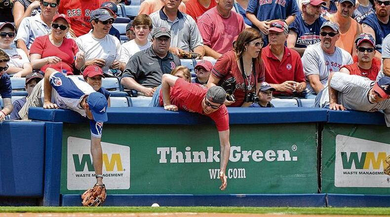 Fans reaching for fouls: The Braves argue that many fans choose field-level seats in the hope that a foul ball will come their way. BRANT SANDERLIN/bsanderlin@ajc.com