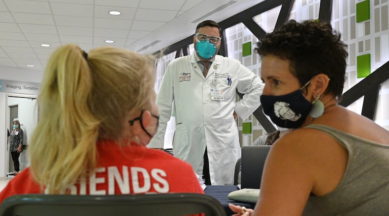 Dr. Stephen Thacker (center), Associate Chief Medical Officer and Pediatric Infectious Disease Specialist, talks to Katie Logsdon (right) and her daughter Lilah Sharp, 12, as Lilah prepares to get vaccinated at Memorial Health’s Dwaine & Cynthia Willett Children’s Hospital of Savannah. (Hyosub Shin / Hyosub.Shin@ajc.com)