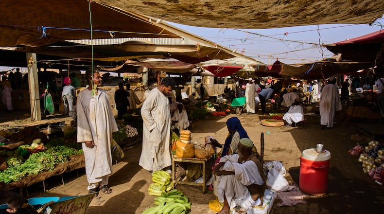 Customers buy vegetables at a market in Omdurman, on the outskirts of Khartoum, Sudan, Sunday, April 26, 2026. (AP Photo/Bernat Armangue)
