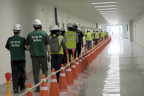 Manufacturing plant employees are escorted outside the Hyundai Motor Group’s electric vehicle plant in early September. 