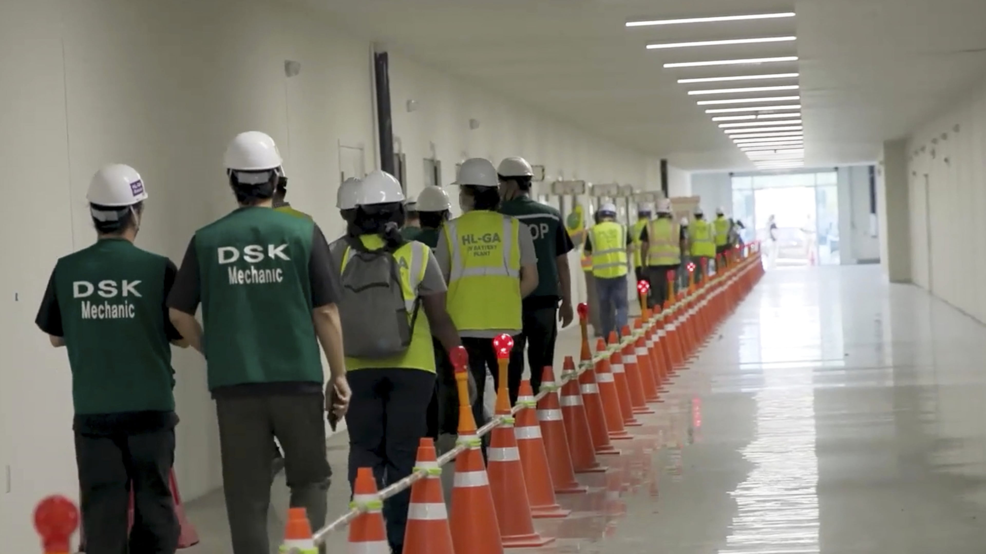 This image from video provided by U.S. Immigration and Customs Enforcement via DVIDS shows manufacturing plant employees being escorted outside the Hyundai Motor Group’s electric vehicle plant, Thursday, Sept. 4, 2025, in Ellabell, Ga. (Corey Bullard/U.S. Immigration and Customs Enforcement via AP)