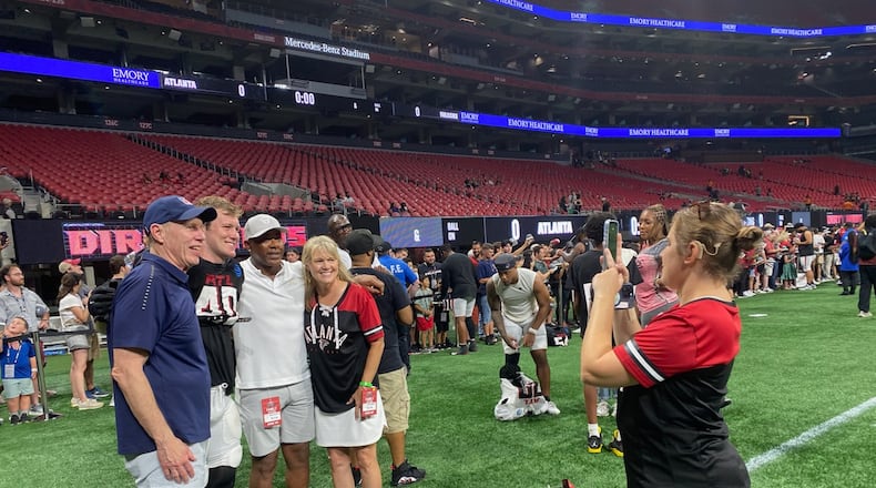 Falcons rookie linebacker J.D. Bertrand poses for a photo following the team's training-camp practice at Mercedes-Benz Stadium August 2, 2024. Bertrand was with his parents Jim (in blue shirt) and Christine (black and red shirt). AJC photo by Ken Sugiura