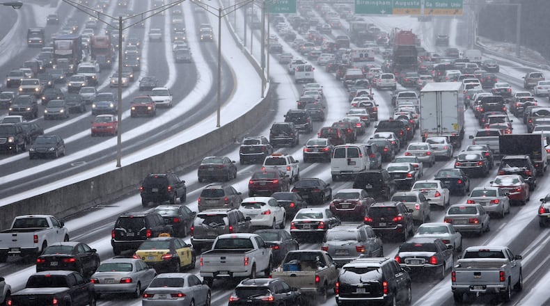 CONNECTOR SHUTS DOWN--January 28, 2014 Atlanta: Traffic inches along the Connector as snow blankets the Metro on Tuesday afternoon January 28, 2014 as seen from the Pryor Street overpass. BEN GRAY / BGRAY@AJC.COM