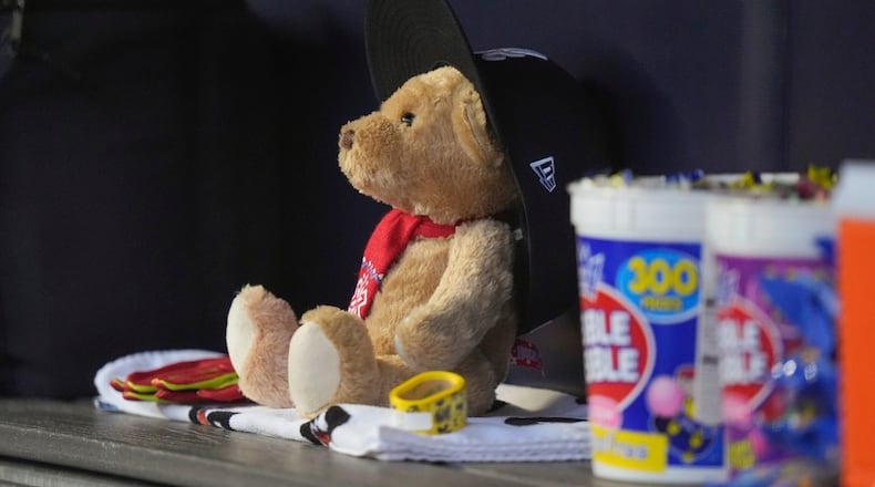 The "Snit Bear" sits in the Atlanta Braves dugout before a baseball game against the New York Yankees, Saturday, June 22, 2024, in New York. "Snit Bear" has become a presence on the team's bench, a stuffed animal with a red bandana around its neck and an oversized blue and white Braves' cap. The toy was given to Marcell Ozuna by manager Brian Snitker. (AP Photo/Frank Franklin II)
