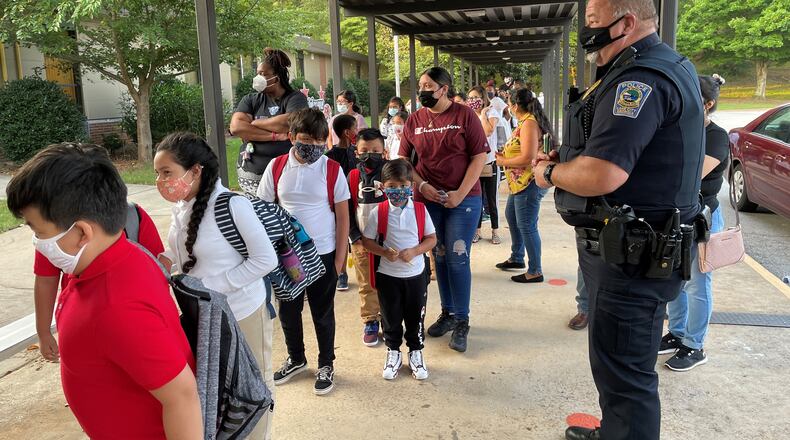 Students arrive for classes on the first day of school at Lake City Elementary School in Morrow on Aug. 2, 2021. This week, the Clayton County School District made masks optional after Gov. Brian Kemp signed into law legislation that allows parents the right to opt out of mask mandates. (Leon Stafford / AJC)