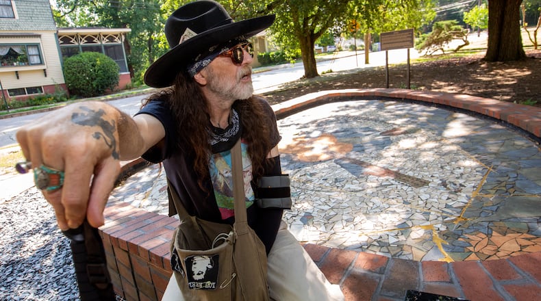 Artist Jason Evers Johnson sits at the foot of his monumental mosaic portrait of blues legend Blind Willie McTell. When the mosaic was threatened by redevelopment, Johnson returned to Atlanta from his home in Italy, to oversee its removal, in pieces, and its reconstruction, outside the Little Five Points Community Center. After the re-assembly was complete, the piece was modified without  Johnson's knowledge. (Jenni Girtman for The Atlanta Journal-Constitution)