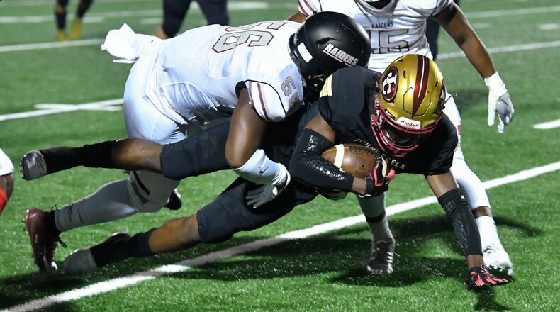 Johns Creek WR Dalton Pearson is tackled by Alpharetta's Breon Smith during Friday's game. (John Amis/Special)