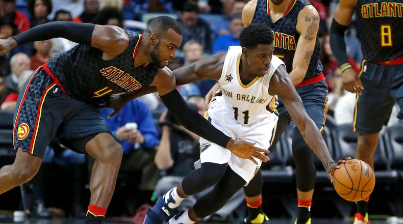 New Orleans Pelicans guard Jrue Holiday (11) and Atlanta Hawks forward Paul Millsap (4) chase a loose ball in the second half of an NBA basketball game in New Orleans, Thursday, Jan. 5, 2017. The Hawks won 99-94. (AP Photo/Gerald Herbert)