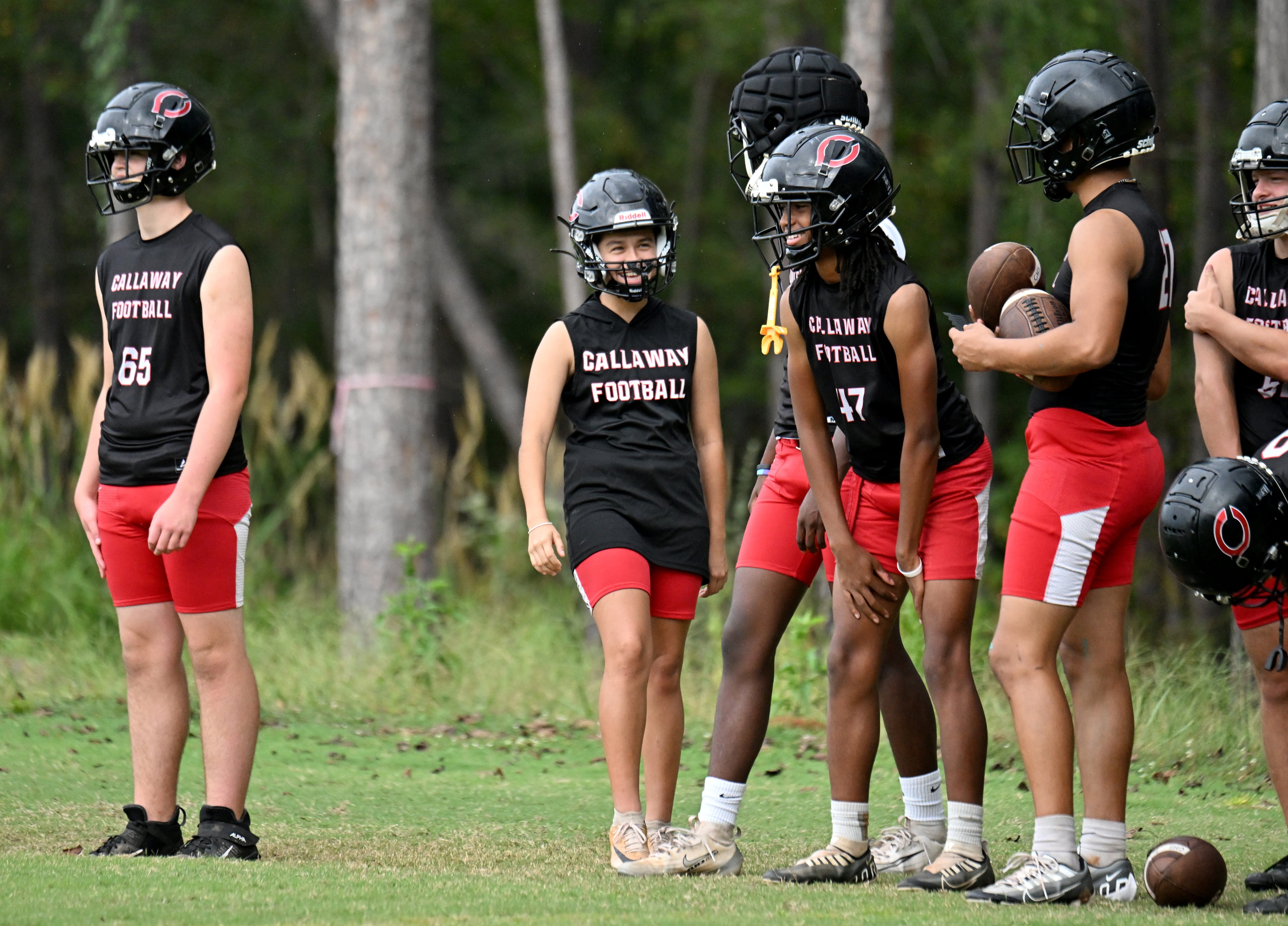 Callaway High's Mia Flores (second from left), said her male teammates have embraced her being part of the football team. Flores said, "Like, none of them acted in a weird way or anything. They all kind of greeted me in a good way … .”(Hyosub Shin/AJC)