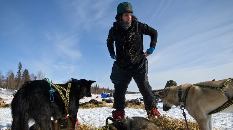 Earlier this month, Sean Underwood tends to his team at a stop along the 975-mile Iditarod trail. (Marc Lester / Achorage Daily News)