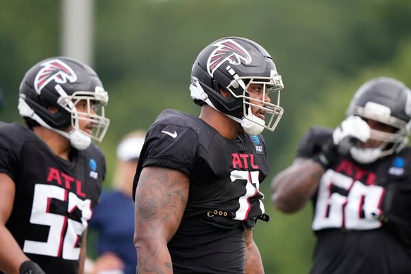 Falcons offensive tackle Elijah Wilkinson (center) runs drills during training camp.