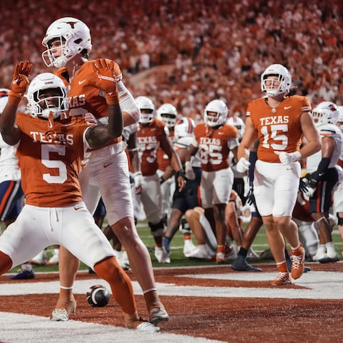 Texas running back Derrek Cooper (5) and Arch Manning, rear, celebrate after Cooper ran the ball for a touchdown during the second half of an NCAA college football game against UTSA in Austin, Texas, Saturday, Sept. 19, 2026. (AP Photo/Eric Gay)