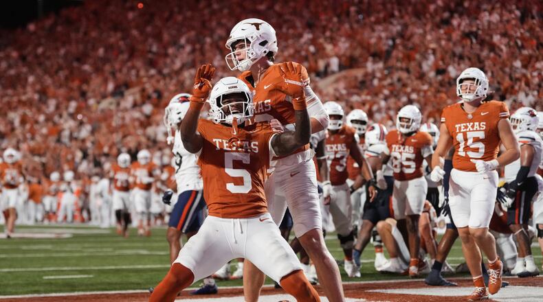 Texas running back Derrek Cooper (5) and Arch Manning, rear, celebrate after Cooper ran the ball for a touchdown during the second half of an NCAA college football game against UTSA in Austin, Texas, Saturday, Sept. 19, 2026. (AP Photo/Eric Gay)