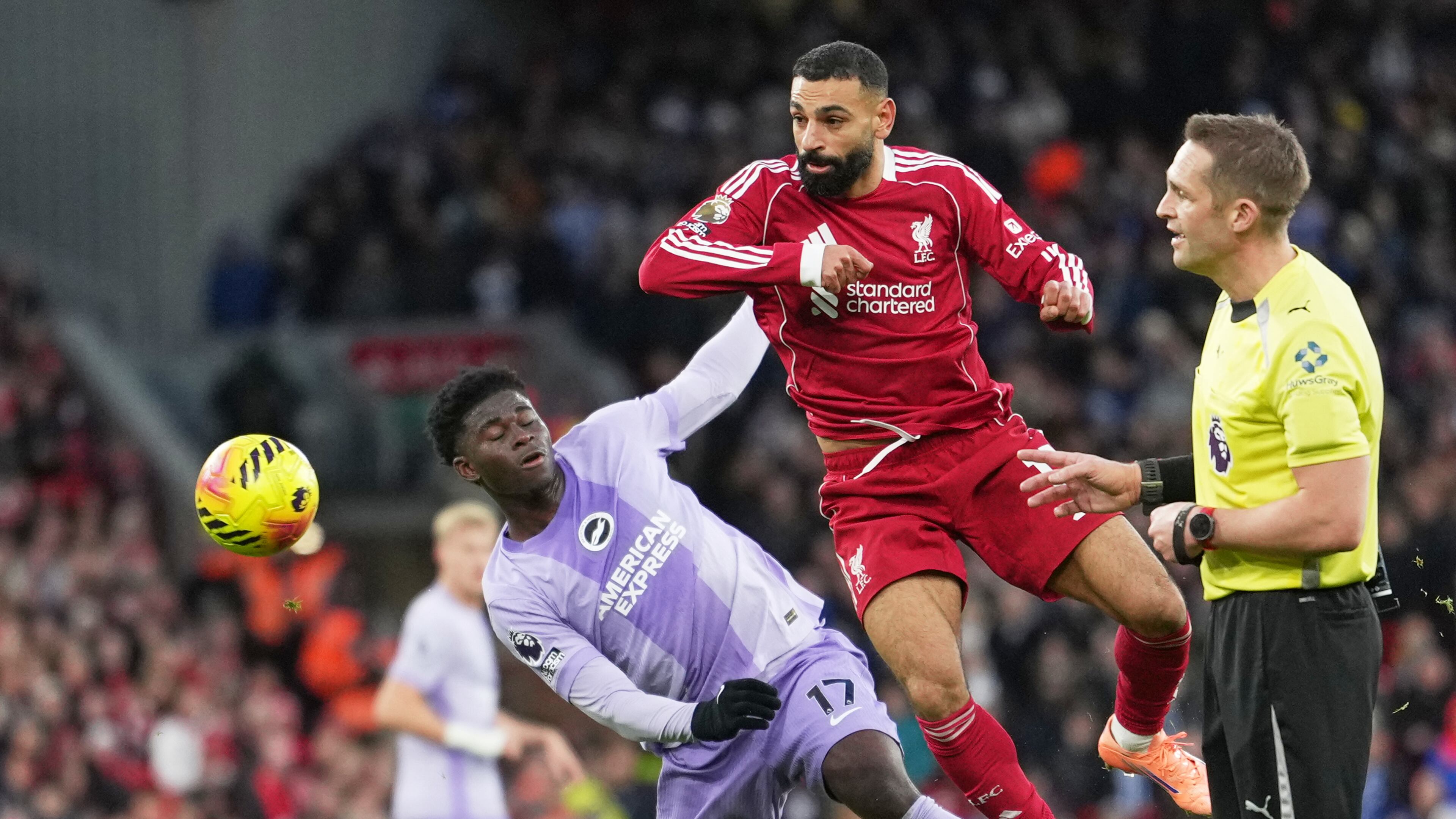 Liverpool's Mohamed Salah, centre, challenges for the ball with Brighton's Carlos Baleba, left, during the English Premier League soccer match between Liverpool and Brighton and Hove Albion in Liverpool, England, Saturday, Dec. 13, 2025. (AP Photo/Jon Super)