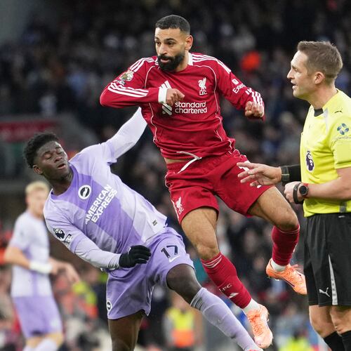 Liverpool's Mohamed Salah, centre, challenges for the ball with Brighton's Carlos Baleba, left, during the English Premier League soccer match between Liverpool and Brighton and Hove Albion in Liverpool, England, Saturday, Dec. 13, 2025. (AP Photo/Jon Super)