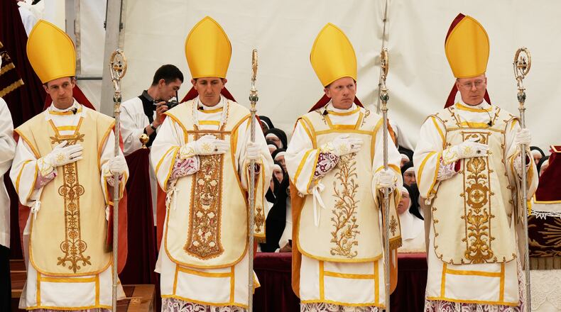 Newly consecrated Bishops, from left, Marc Hanappier, Michel Poinsinet de Sivry, Michael Goldade and Pascal Schreiber wearing their miters and holding their pastoral staffs, stand at the end of their consecration ceremony in a tent set up outside the Society of St. Pius X seminary in Econe, Switzerland, Wednesday, July 1, 2026. (AP Photo/Baz Ratner)
