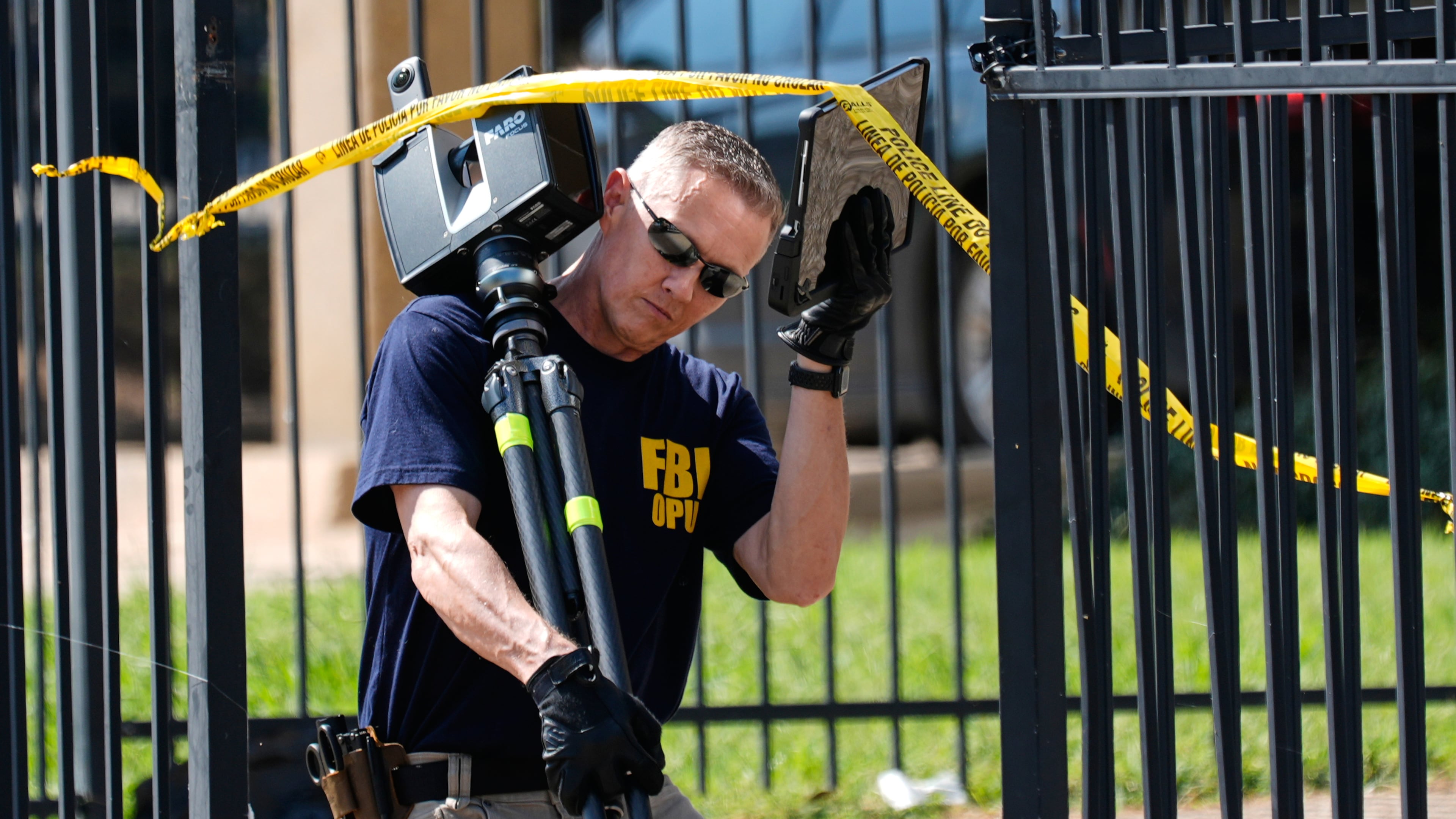 FBI agents investigate the crime scene near a U.S. Immigration and Customs Enforcement office Thursday, Sept. 25, 2025, in Dallas. (AP Photo/Tony Gutierrez)