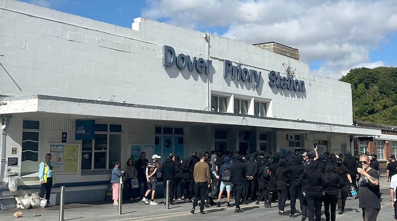 Protesters gather at Dover Priory train station after black-clad and masked demonstrators blocked roads during a protest, in Dover, England, Saturday, Sept. 5, 2026. (Oscar Rihll/PA via AP)