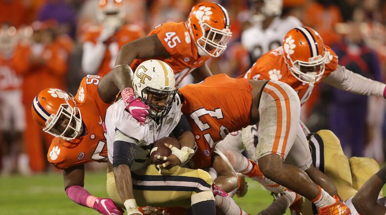 Teammates Jabril Robinson (50) and Tre Lamar (57) of the Clemson Tigers stop KirVonte Benson (30) of the Georgia Tech Yellow Jackets during their game at Memorial Stadium on October 28, 2017 in Clemson, South Carolina. (Photo by Streeter Lecka/Getty Images)