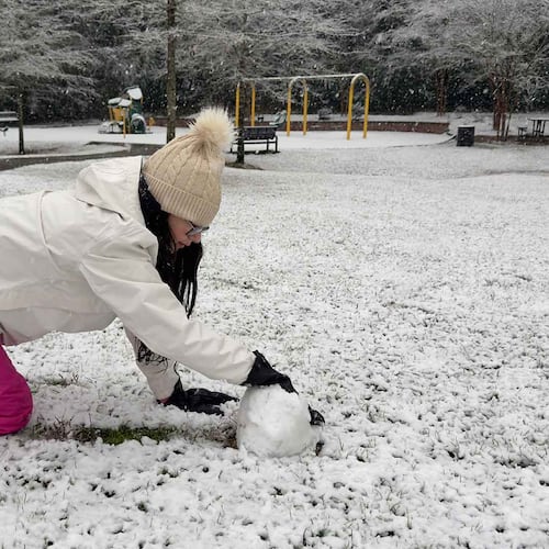 Olivia Thanos, 13, rolls a snowball at Henry Burns Park in Macon on Sunday.