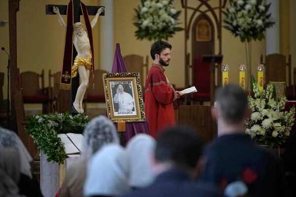 Parishioners attend a service sitting in front of a photo of the late Pope Francis after the news of his death at the Cathedral of the Immaculate Conception in Moscow, Russia, Monday, April 21, 2025. (AP Photo/Pavel Bednyakov)