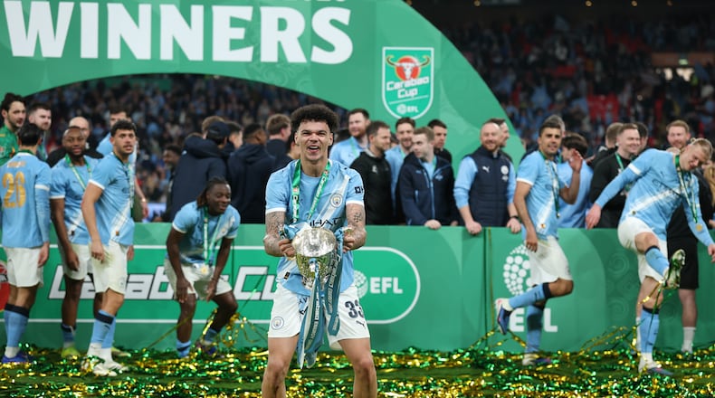 Manchester City's Nico O'Reilly celebrates with the trophy after winning the English League Cup final soccer match between Arsenal and Manchester City in London, Sunday, March 22, 2026. (AP Photo/Richard Pelham)