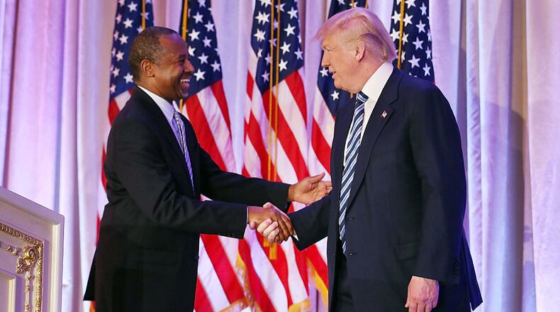 Then Republican presidential candidate Donald Trump shakes hands with former presidential candidate Ben Carson as he receives Carson’s endorsement at the Mar-A-Lago Club on March 11, 2016 in Palm Beach, Florida. Carson, now HUD secretary, was stuck in an elevator for about 15 minutes while on a tour of  a low income housing development.
