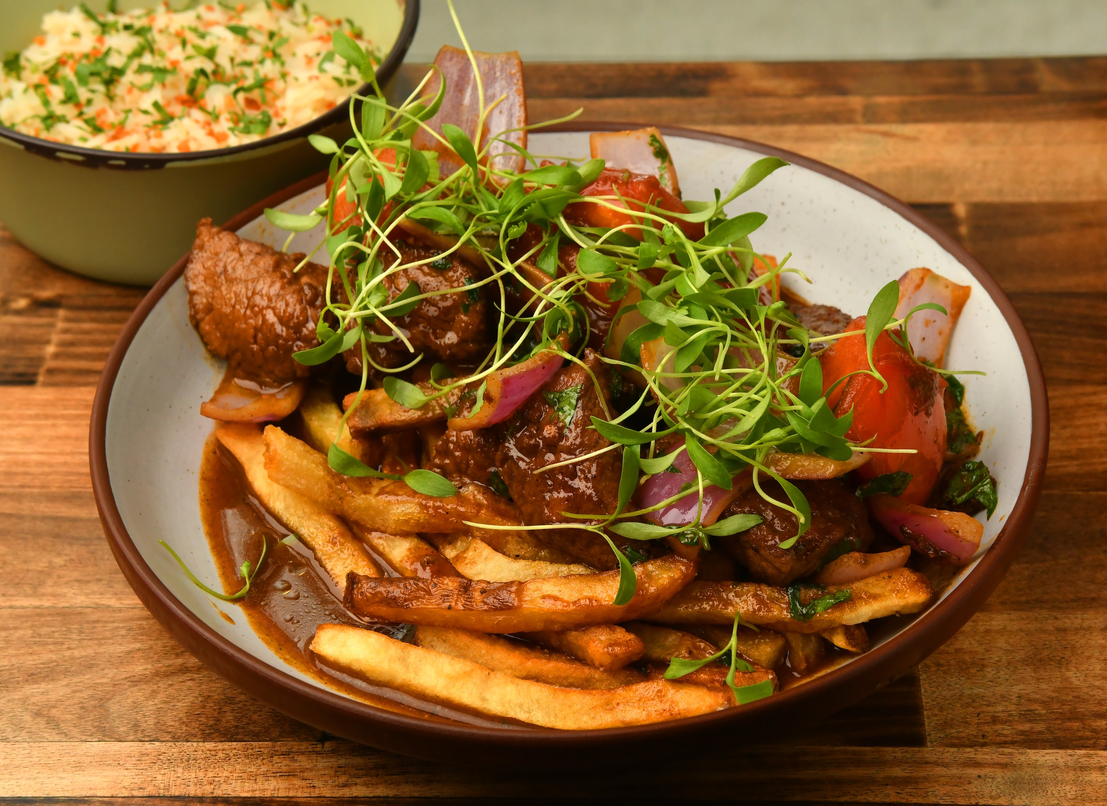 Lomo saltado at Tio Lucho's brings uber-tender slices of stir-fried beef in a rich sauce with onions and tomatoes, served over french fries.(Chris Hunt for the AJC)