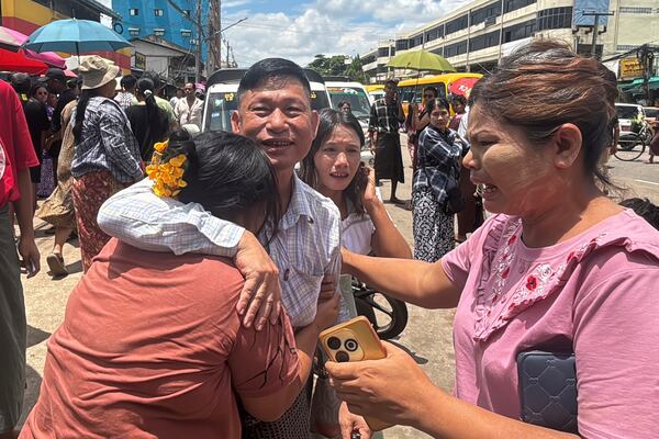 A released prisoner, center, is welcomed by family members outside the main gate of Insein prison as the head of Myanmar’s military government granted amnesty to thousands of prisoners to mark the country's traditional New Year Thursday, April 17, 2025, in Yangon, Myanmar. (AP Photo/Thein Zaw)