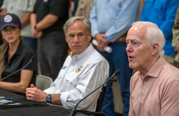 Sen. John Cornyn, right, speaks to media during a press conference as Homeland Security Secretary Kristi Noem, left, and Gov. Greg Abbott, center, listen after recent flooding along the Guadalupe River during a press conference on Saturday, July 5, 2025, in Kerrville, Texas. (AP Photo/Rodolfo Gonzalez)