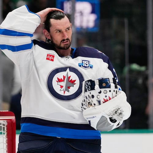 FILE - Winnipeg Jets goaltender Connor Hellebuyck stands by the net during a time out from play against the Dallas Stars in the first period of an NHL hockey game, April 2, 2026, in Dallas. (AP Photo/Tony Gutierrez, File)