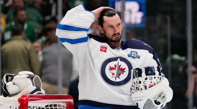 FILE - Winnipeg Jets goaltender Connor Hellebuyck stands by the net during a time out from play against the Dallas Stars in the first period of an NHL hockey game, April 2, 2026, in Dallas. (AP Photo/Tony Gutierrez, File)