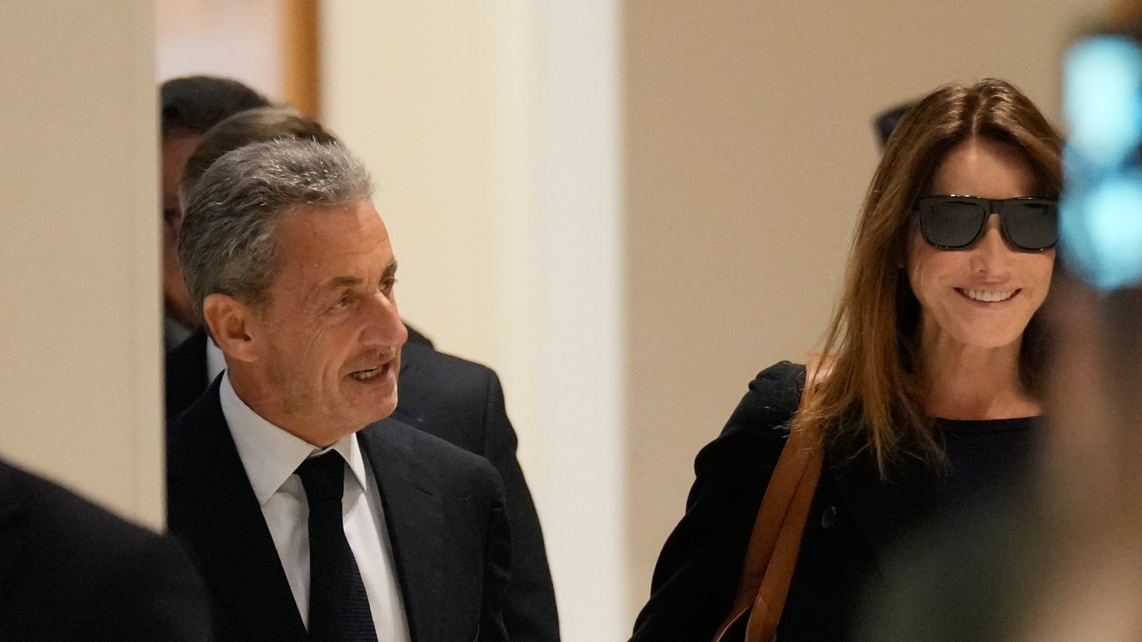 Former French President Nicolas Sarkozy and his wife Carla Bruni Sarkozy arrive to the courtroom for his verdict for alleged illegal financing of his 2007 presidential campaign by the government of then-Libyan leader Moammar Gadhafi, Thursday, Sept. 25, 2025 in Paris. (AP Photo/Michel Euler)