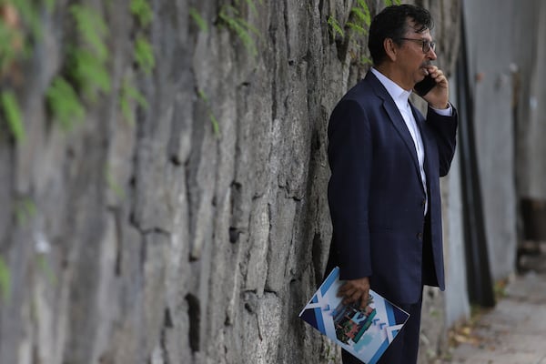 Jaime Quintanilla, attorney for Salvador Enrique Anaya, a critic of President Nayib Bukele's government, speaks on his cell phone outside a police station after arriving to visit his client in San Salvador, Tuesday, June 10, 2025. Anaya was detained on June 7 for alleged money laundering and asset laundering. (AP Photo/Salvador Melendez)