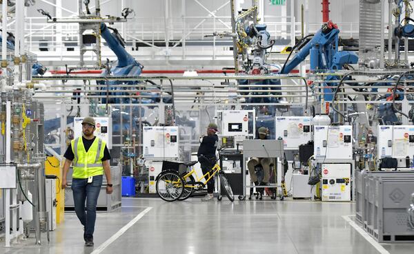 Manufacturing workers assemble electric vehicles at Rivian in Normal, Ill., on July 20, 2022. (Photo for The Atlanta Journal-Constitution by Ron Johnson)