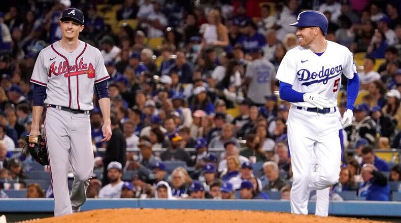 Los Angeles Dodgers' Freddie Freeman, right, smiles at Atlanta Braves starting pitcher Max Fried after being thrown out at first during the fourth inning of a baseball game Tuesday, April 19, 2022, in Los Angeles. (AP Photo/Mark J. Terrill)