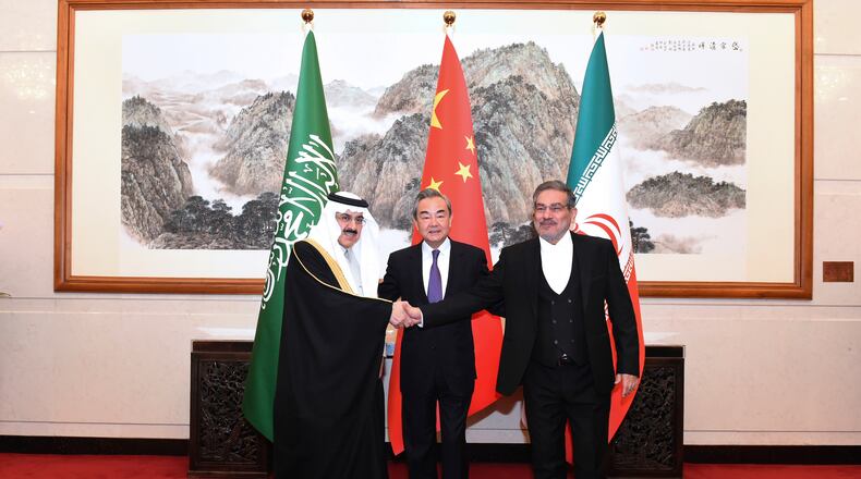 FILE - In this photo released by Xinhua News Agency, Ali Shamkhani, then secretary of Iran's Supreme National Security Council, right, shakes hands with Saudi national security adviser Musaad bin Mohammed al-Aiban, left, as Wang Yi, China's most senior diplomat, looks on for a photo during a closed meeting held in Beijing, on March 11, 2023. (Luo Xiaoguang/Xinhua via AP, File)