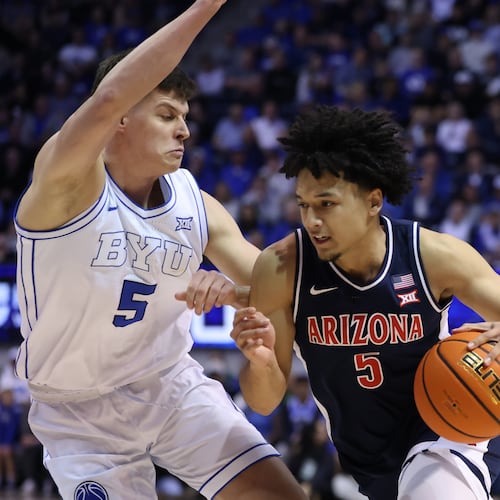 Arizona guard Brayden Burries, right, moves the ball as BYU forward Mihailo Boskovic (5) defends during the second half of an NCAA college basketball game, Monday, Jan. 26, 2026, in Provo, Utah. (AP Photo/Rob Gray)