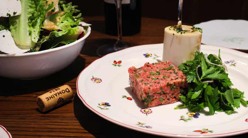 Among the hors d'oeuvres at Little Sparrow are the salade maison (left) and the filet Américain, served with bone marrow and parsley. Courtesy of Little Sparrow