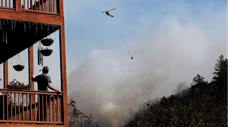 A helicopter works dropping water on the Rock Mountain Fire as it approaches homes on Wednesday, Nov. 16, 2016, in Tate City. Curtis Compton/ccompton@ajc.com