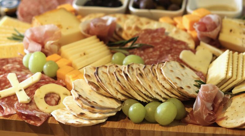 An arrangement of crackers, cheeses, meats, fruits and spreads is prepared for guests at a gathering of friends at an apartment in Flagstaff, Ariz., on Sunday, Feb. 15, 2026. (AP Photo/Cheyanne Mumphrey)