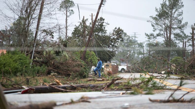 A man steps over debris in a neighborhood that was damaged by a tornado, Monday, Jan. 23, 2017, in Albany, Ga. (AP Photo/Branden Camp)